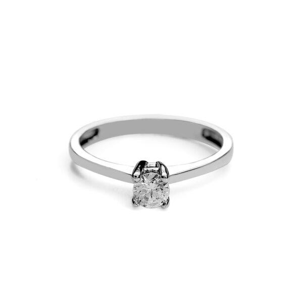La imagen muestra un anillo de compromiso solitario con un diamante o circón en el medio sostenido de 4 brazos. El anillo puede ser hecho en Oro Miel, Oro Blanco y Oro Rosa, todos de 14 kilates o quilates. El anillo está acostado con la piedra hacia adelante.